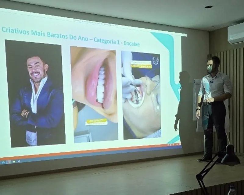 André Cherman ao lado de um slide com exemplos de anúncios para clínicas odontológicas